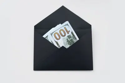 Envelope holding hundred-dollar bills, like a cash bonus