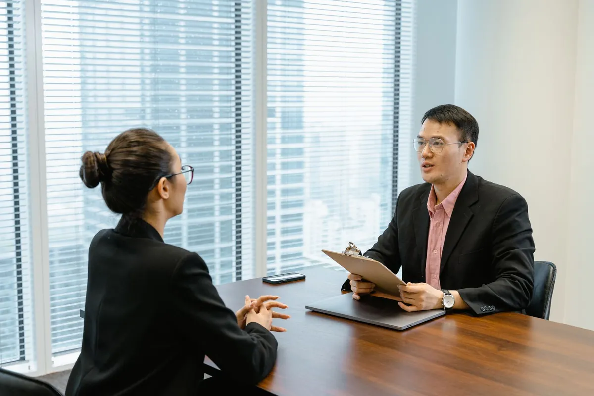 Employee meeting with her manager across a conference table to discuss pay