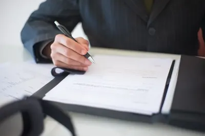 Hand signing an agreement with a pen