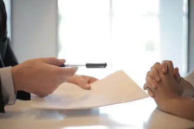 Manager handing a job offer contract to a candidate to sign