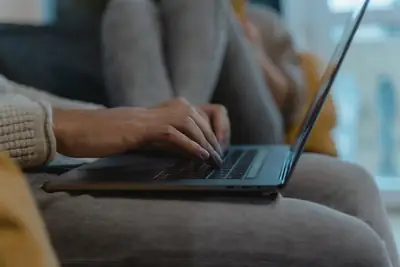 Hands typing an email on a laptop keyboard