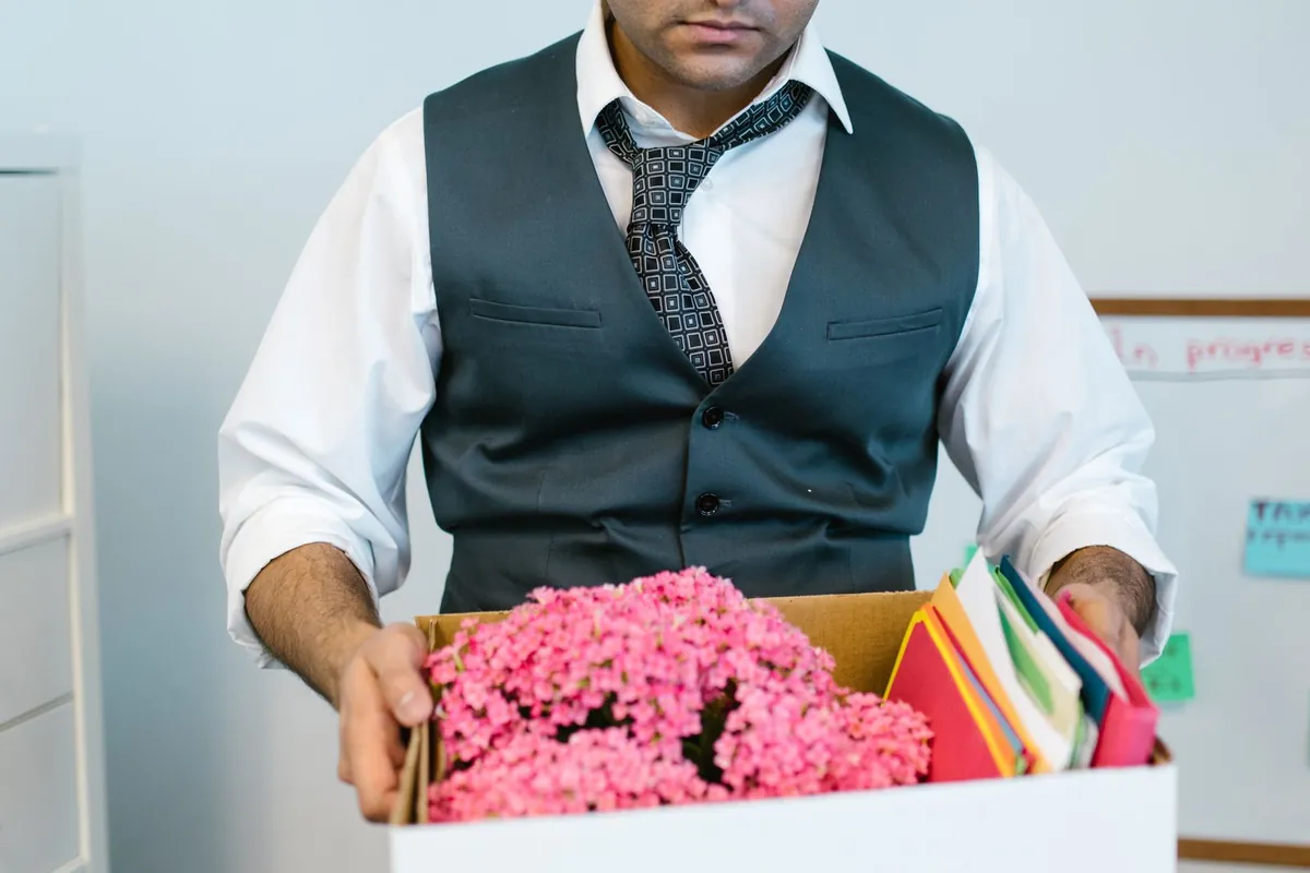 Office worker carrying a box of personal belongings after a layoff